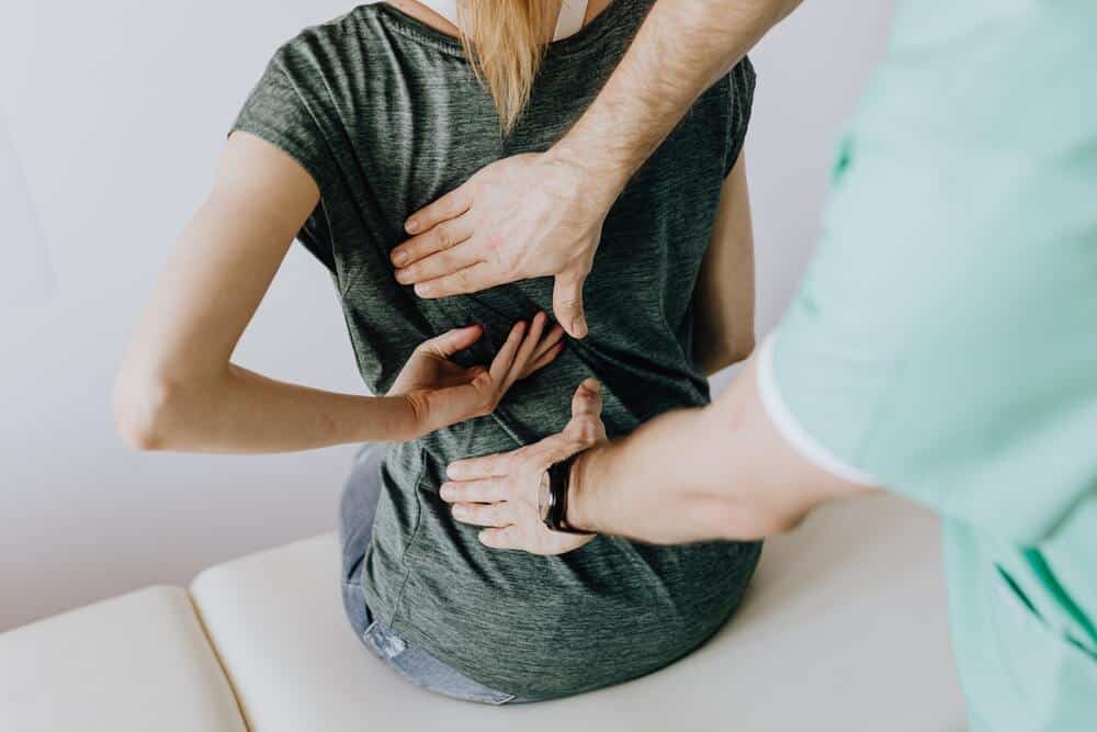 fisio revisando la espalda de una paciente