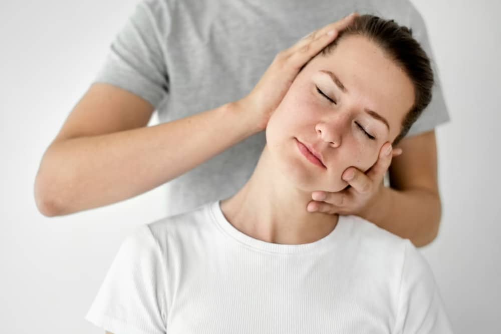 osteopata inclinando la cabeza de una paciente