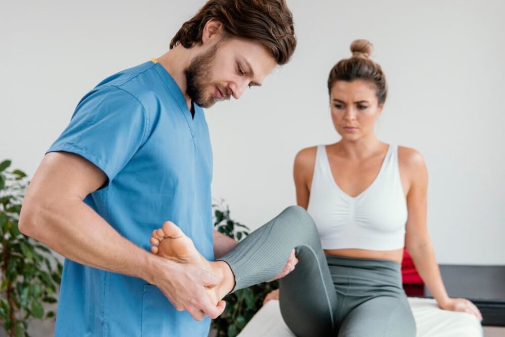 terapeuta osteopático masculino ayudando deportista