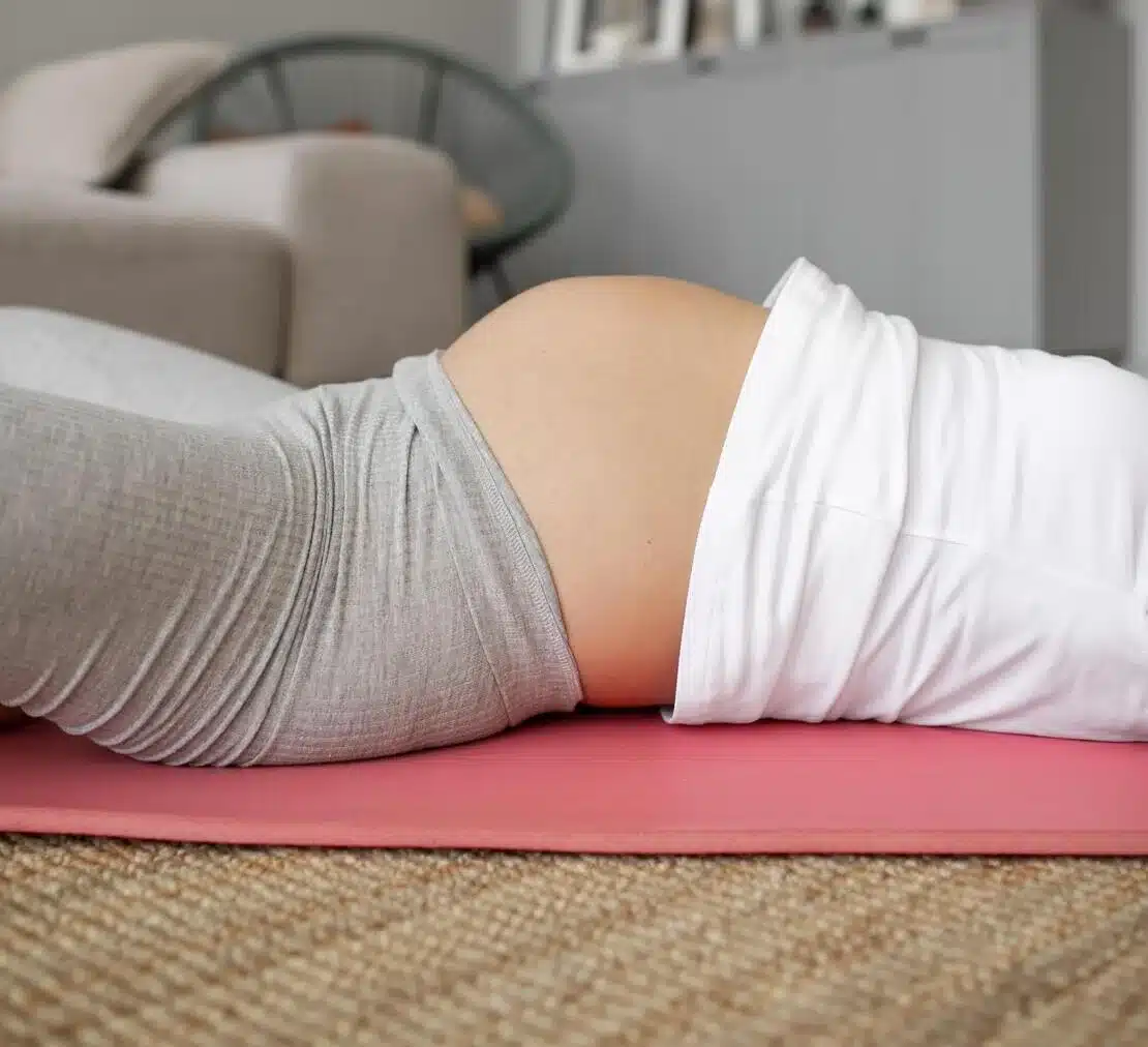 mujer embarazada haciendo yoga en casa